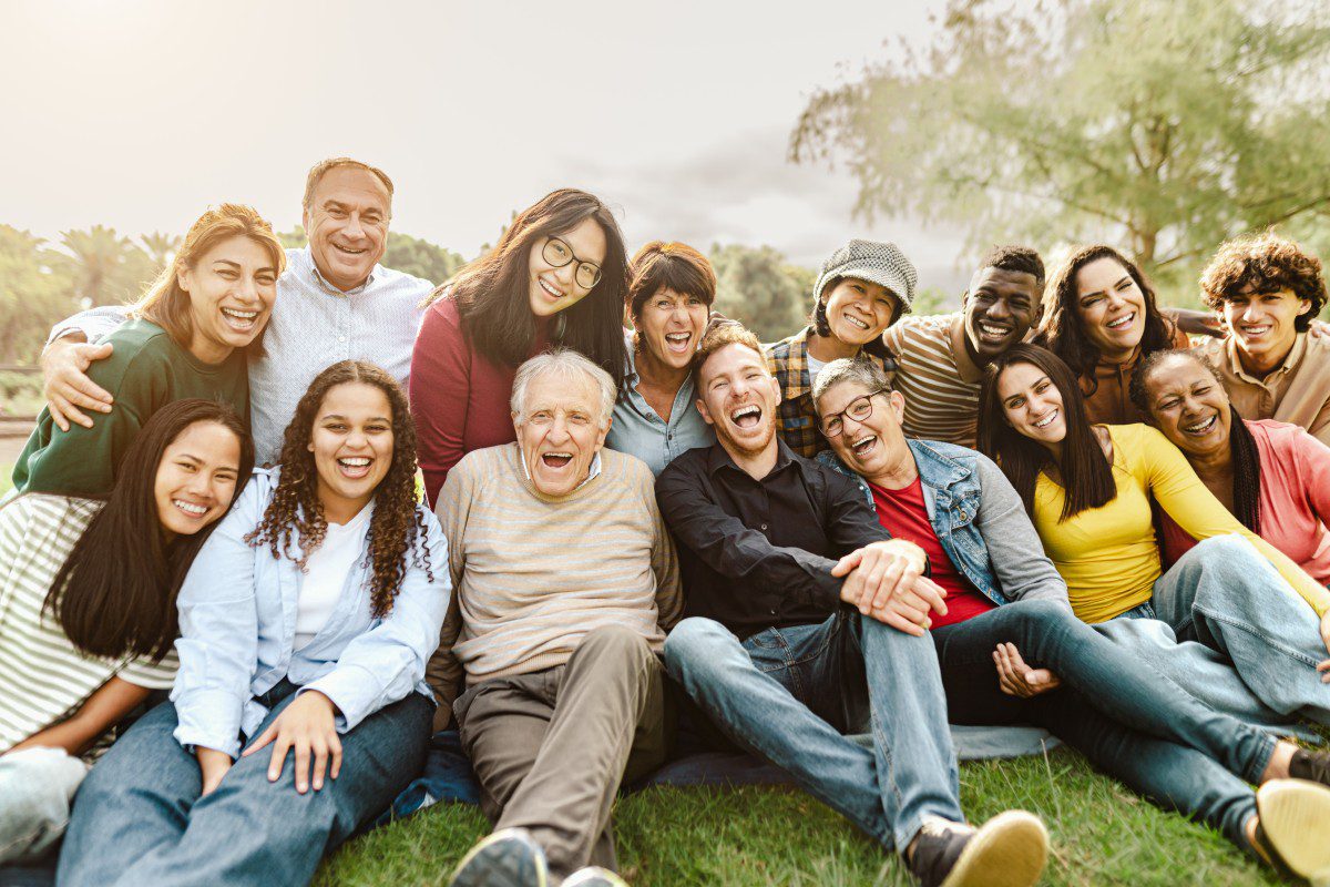 GettyImages-1480574526 Diverse group of people smiling outdoors.
