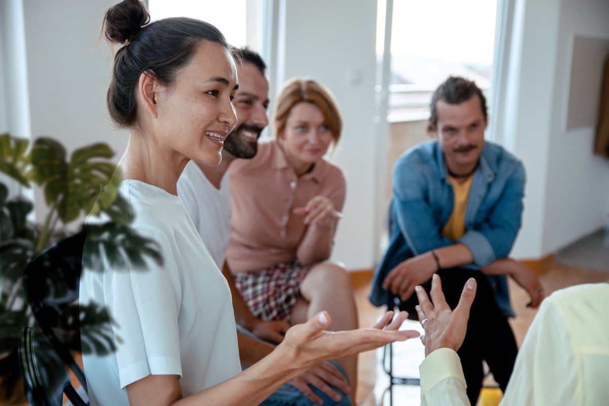 GettyImages-1338931651 Group having a discussion in a room.