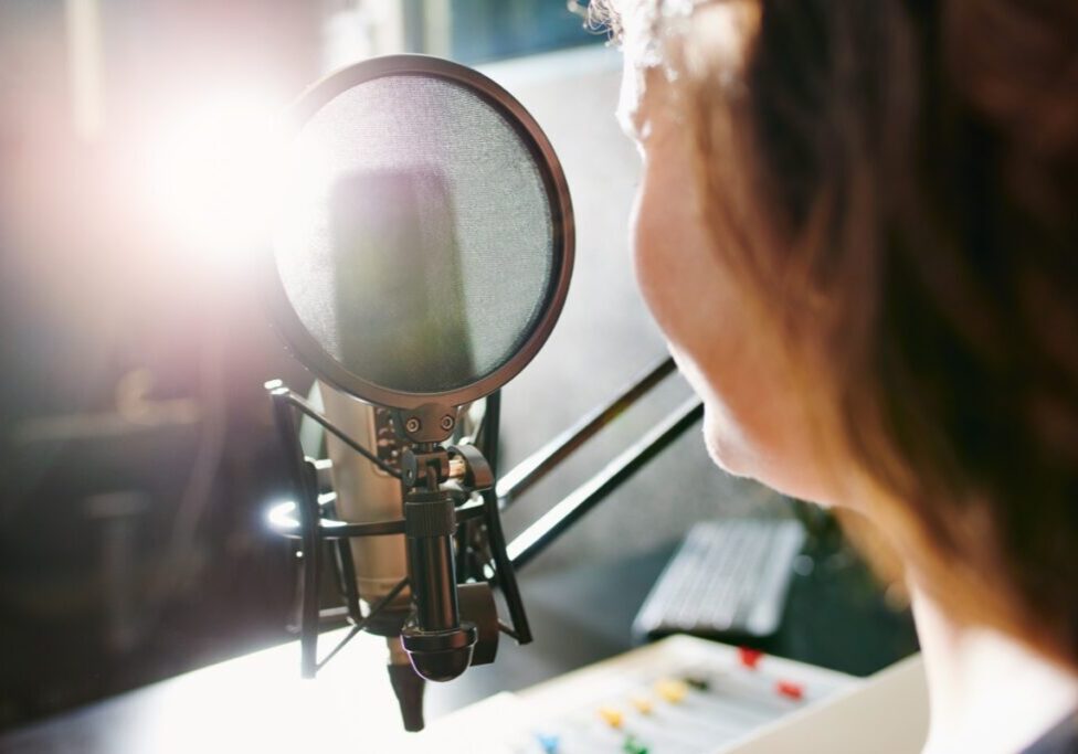 Person speaking into a studio microphone.