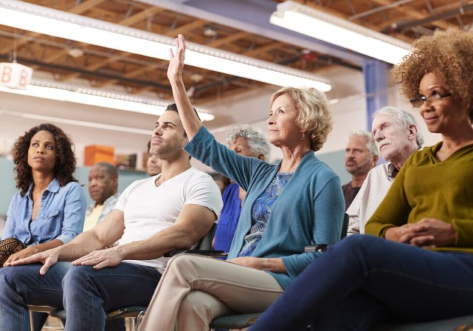 Audience member raising hand in classroom setting.