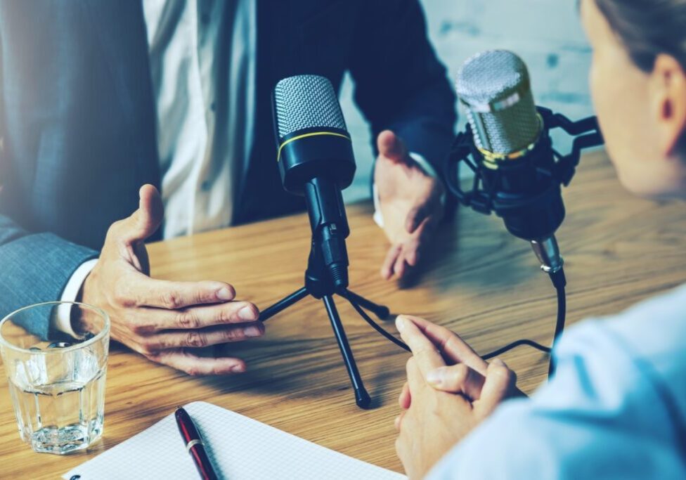 Podcast interview with microphones on table.