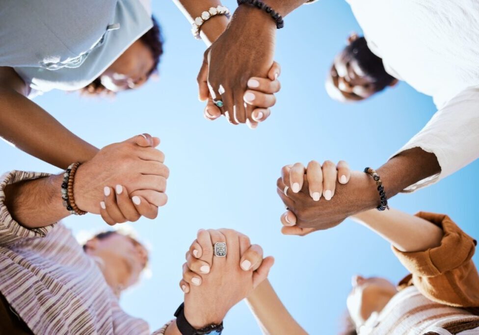 Diverse group holding hands in unity.