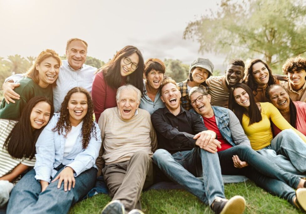 Diverse group of people smiling outdoors.
