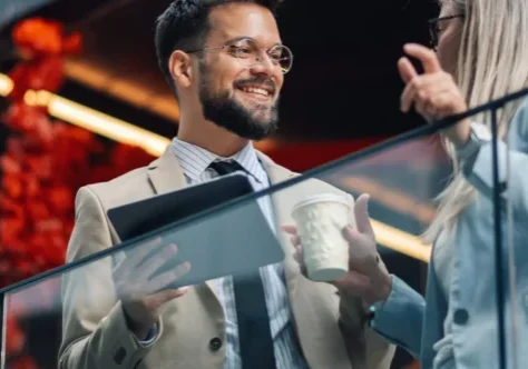 Business professionals conversing on modern office balcony.