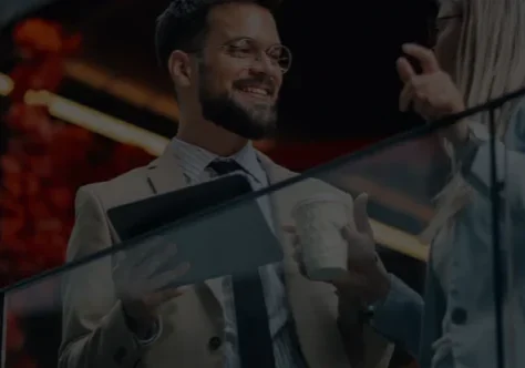 Two professionals conversing on glass balcony.