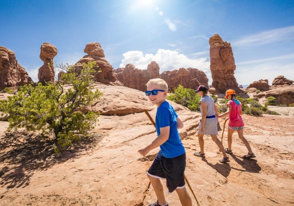 Family hiking in sunny desert landscape.